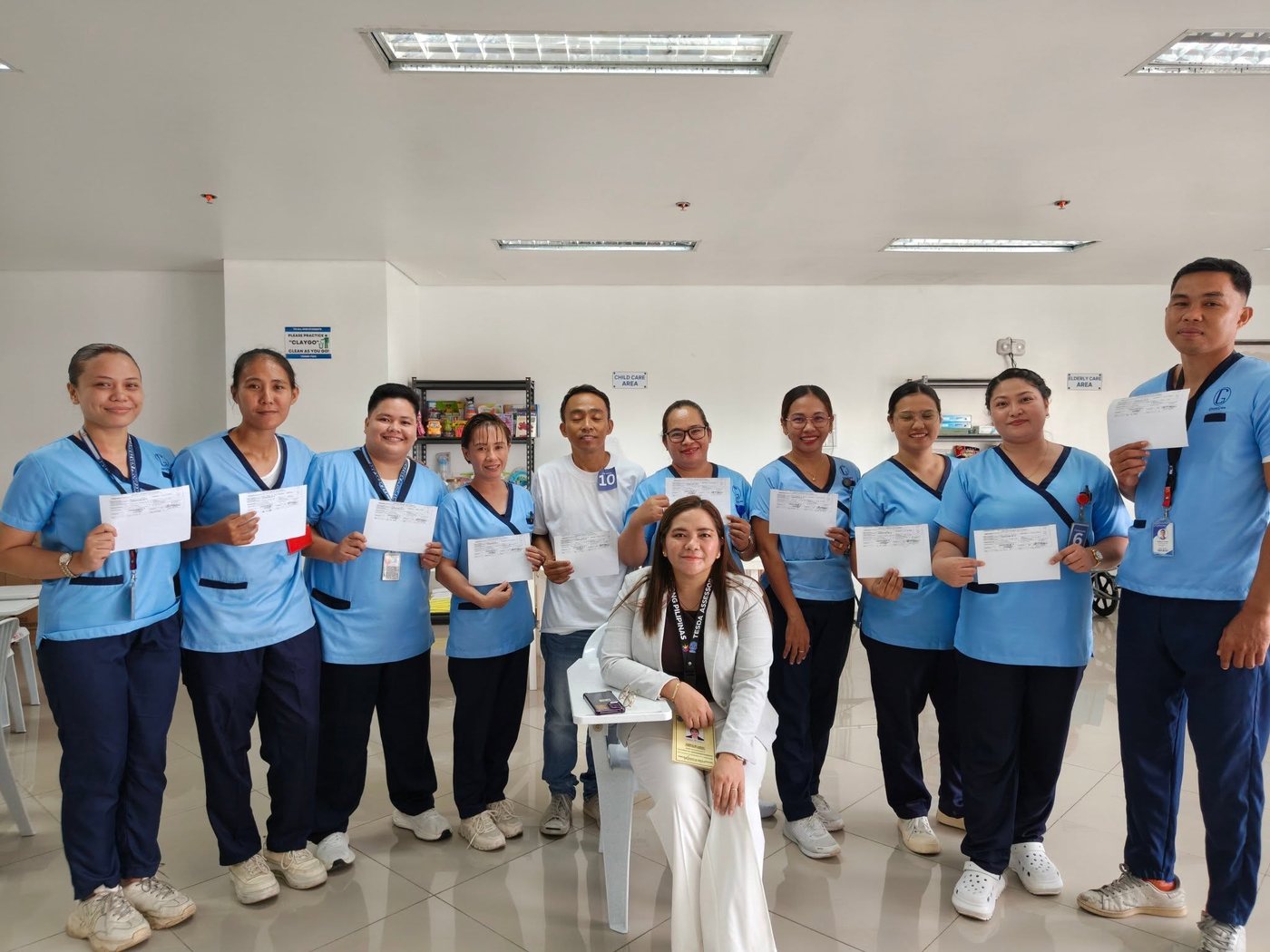 CleverCare students holding their TESDA NC II certification results